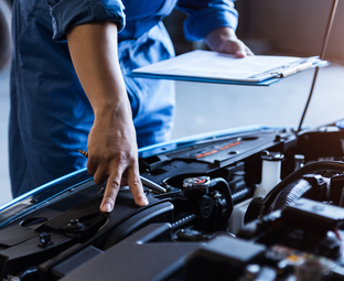 Mechanic inspecting a vehicle with a service checklist